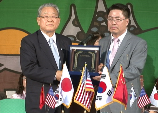 Mutual giving of a contribution award between WREA Chairman and President Young-kee Lee and ICHPER.SD President Dong-ja Yang